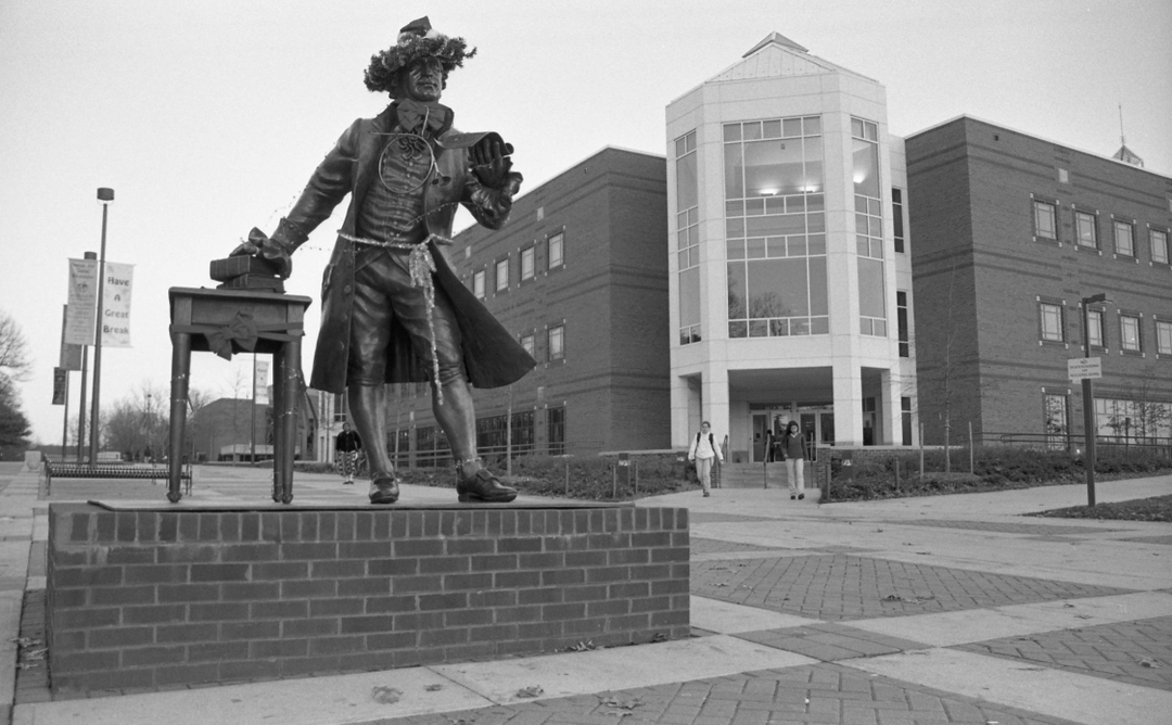 Northwest entrance to the George W. Johnson Learning Center with statue of George Mason wearing a hat