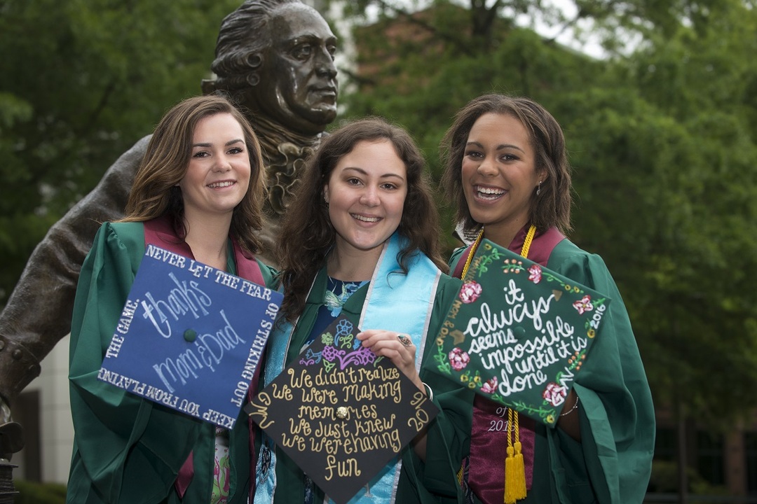 Graduating students pose with the George Mason statue